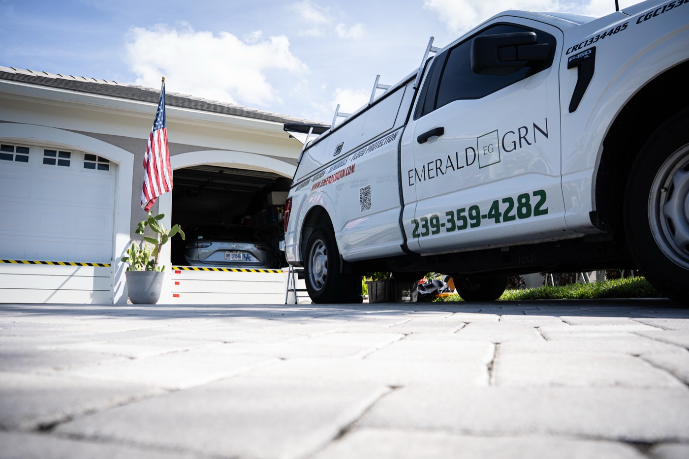Emerald Green Property Services truck on-site at a residential flood barrier installation