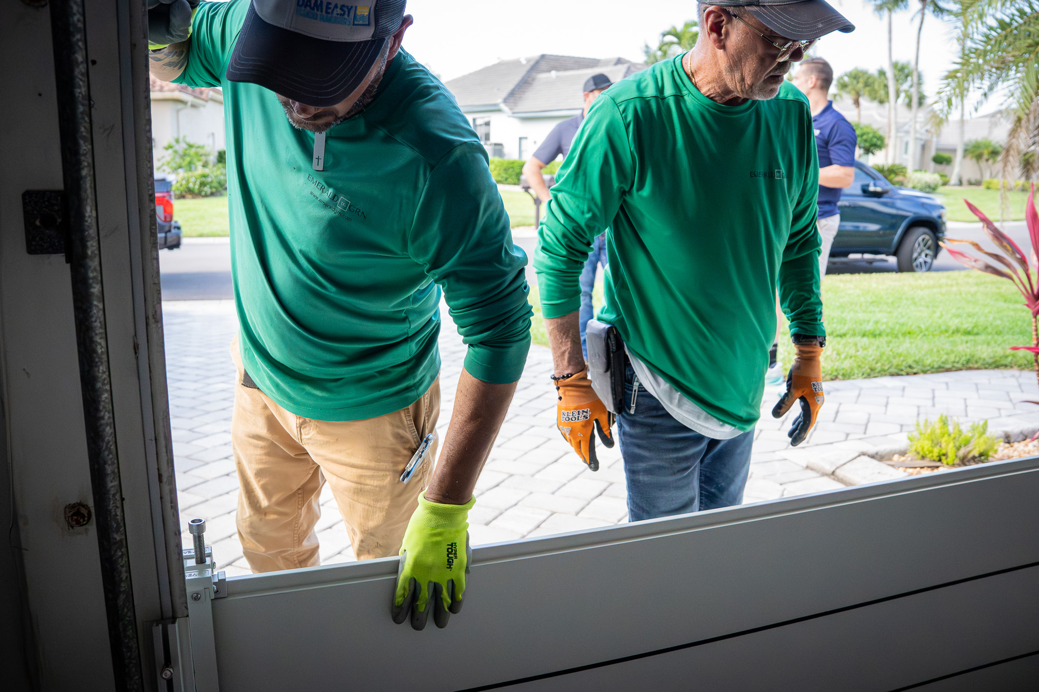 Emerald Green technician fitting a flood barrier track to a sliding door threshold